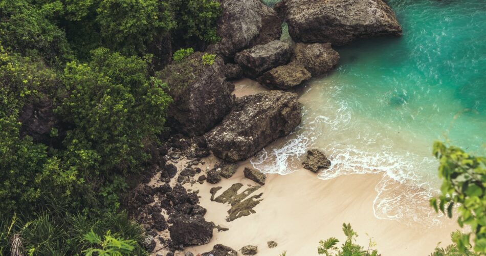 aerial view of seashore near large grey rocks