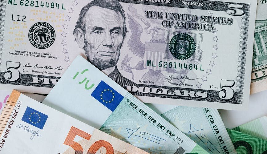 stack of different currency with photo of men and buildings