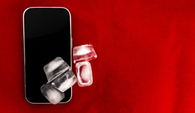 The concept of overheating and fire hazard. Cooling the latest smartphone with ice cubes.