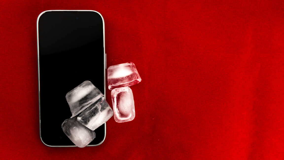 The concept of overheating and fire hazard. Cooling the latest smartphone with ice cubes.